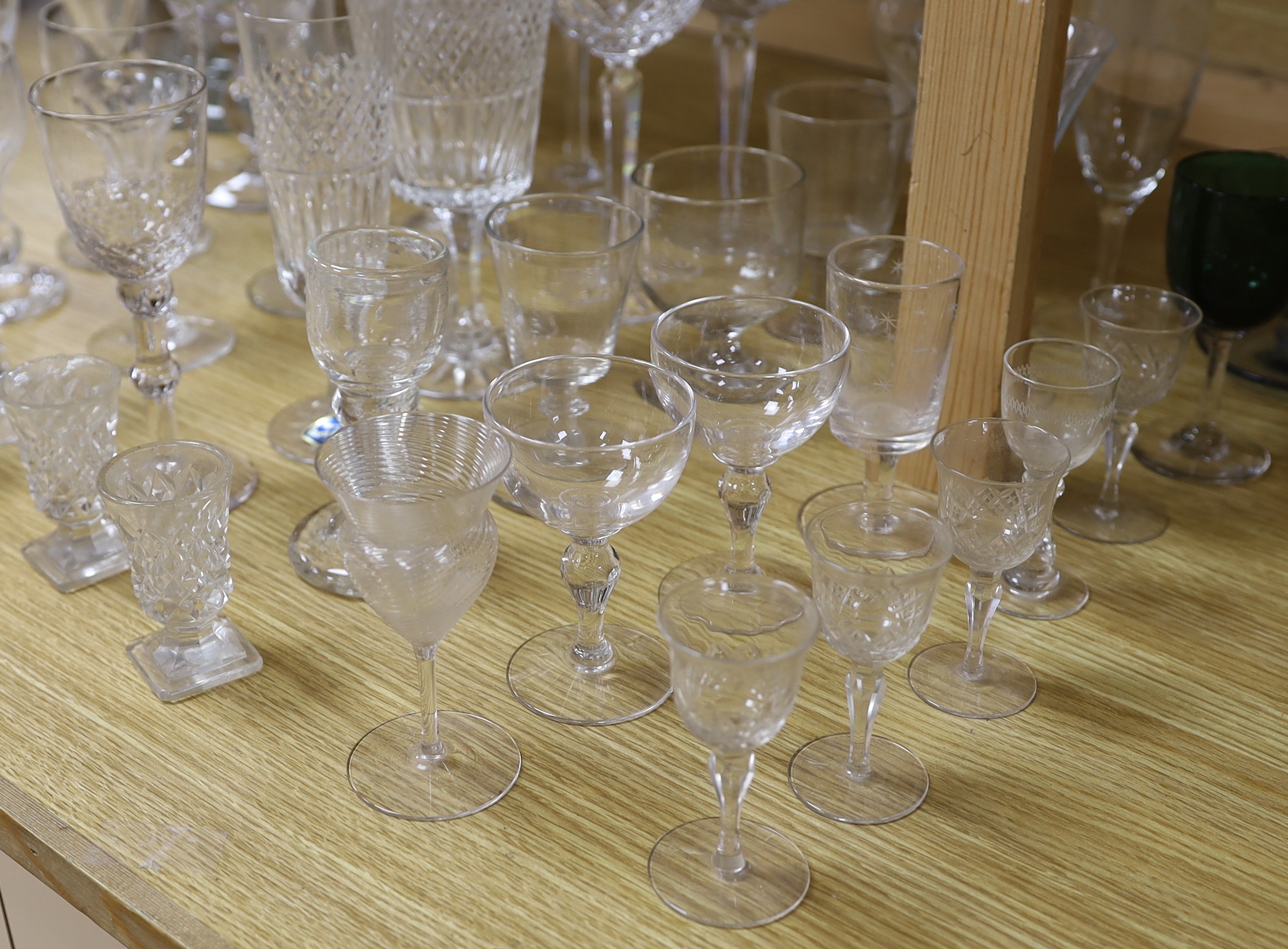 A large glass centrepiece, a teardrop trumpet shaped vase and a collection of 19th and 20th century wine and other drinking glasses